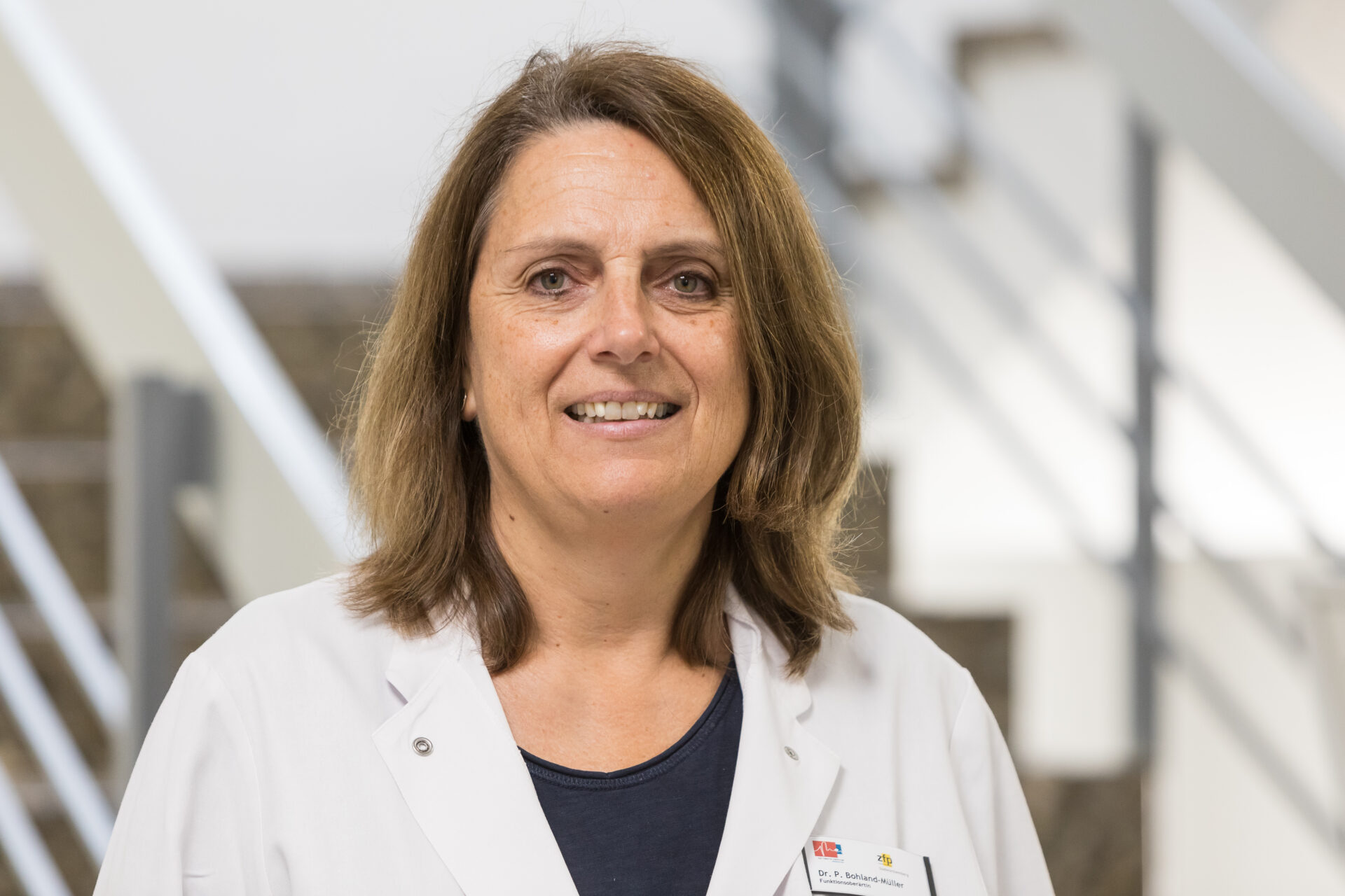 Porträt der lächelnden Ärztin Petra Bohland-Müller in weißem Arztkittel.