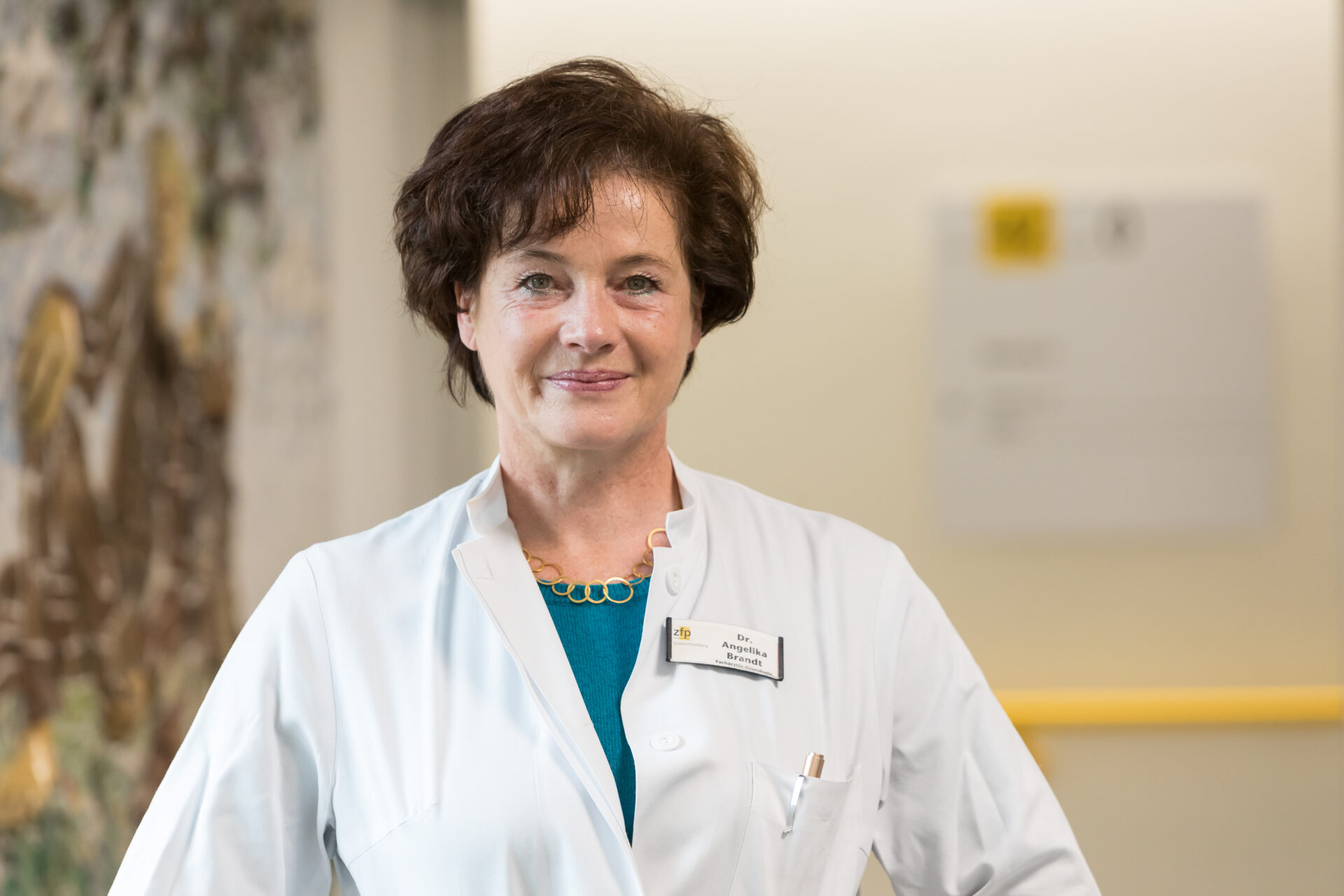 Porträt der lächelnden Ärztin Angelika Brandt in weißem Arztkittel.