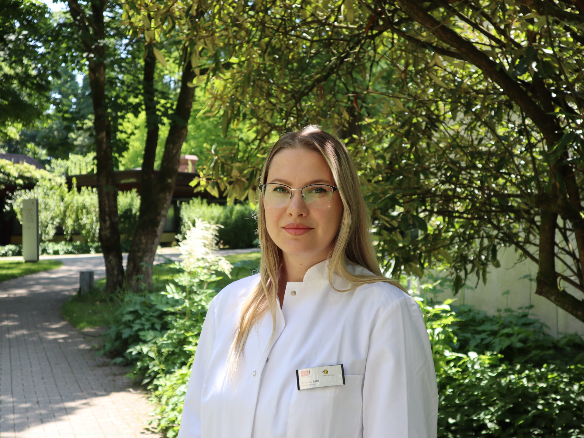 Porträt der lächelnden Ärztin Amela Zulic in weißem Arztkittel.