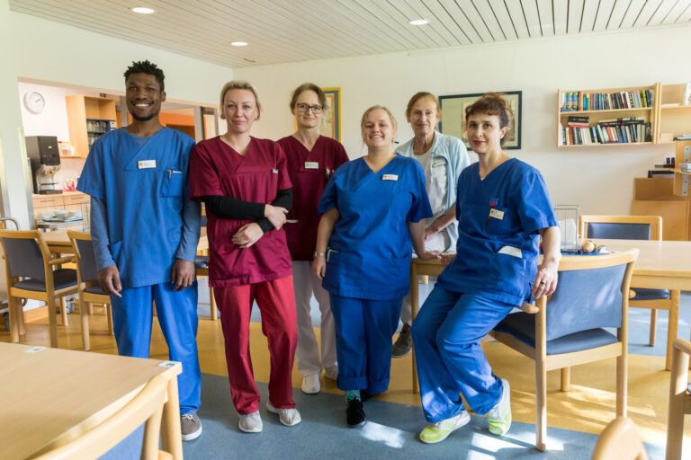 Lächelndes Gruppenbild der Pflegefachkräfte auf der Station 2032.